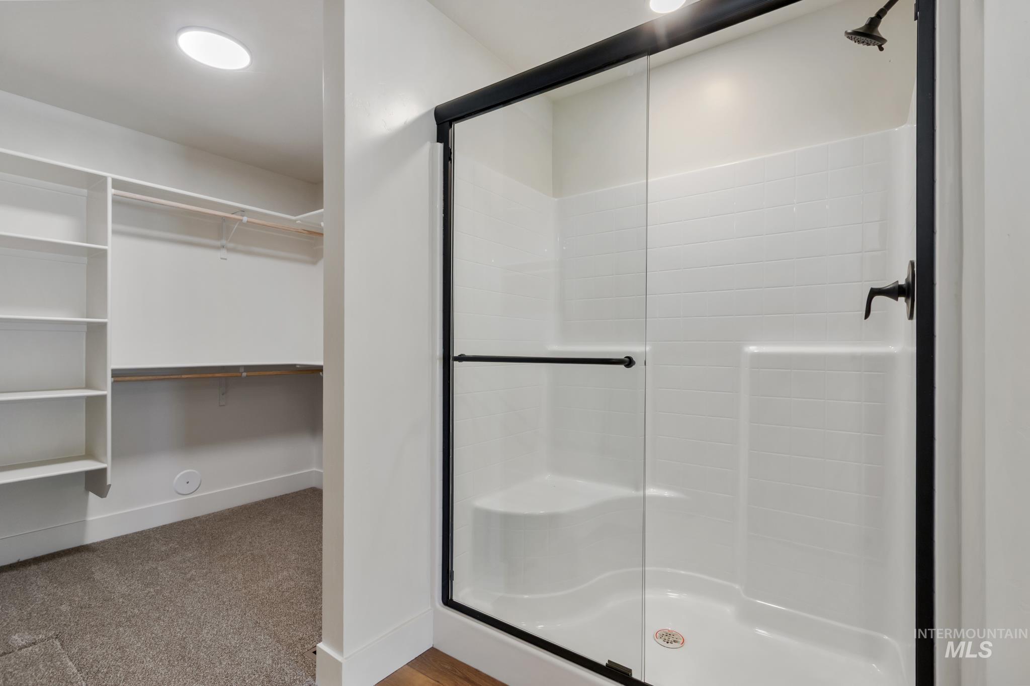 321 North 11th Street Parma, ID 83660 - Photo 27 of 36 Shower enclosure with a black-framed glass door, white subway tile-patterned surround, and built-in bench seating
