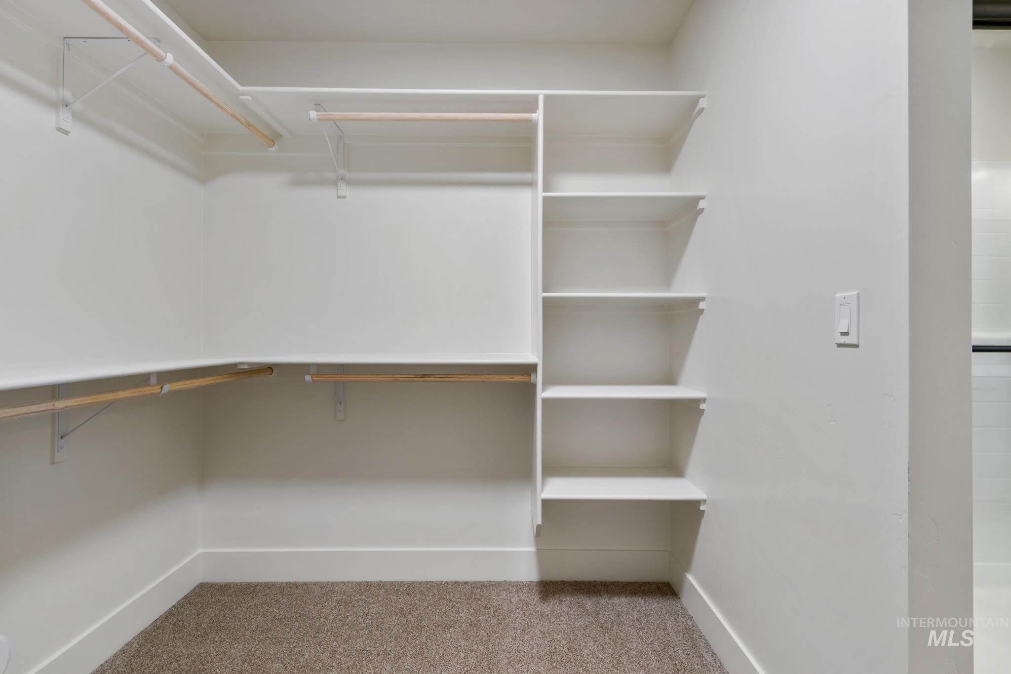 321 North 11th Street Parma, ID 83660 - Photo 29 of 36 Walk-in closet featuring built-in shelving, multiple hanging rods, and a neutral carpeted floor