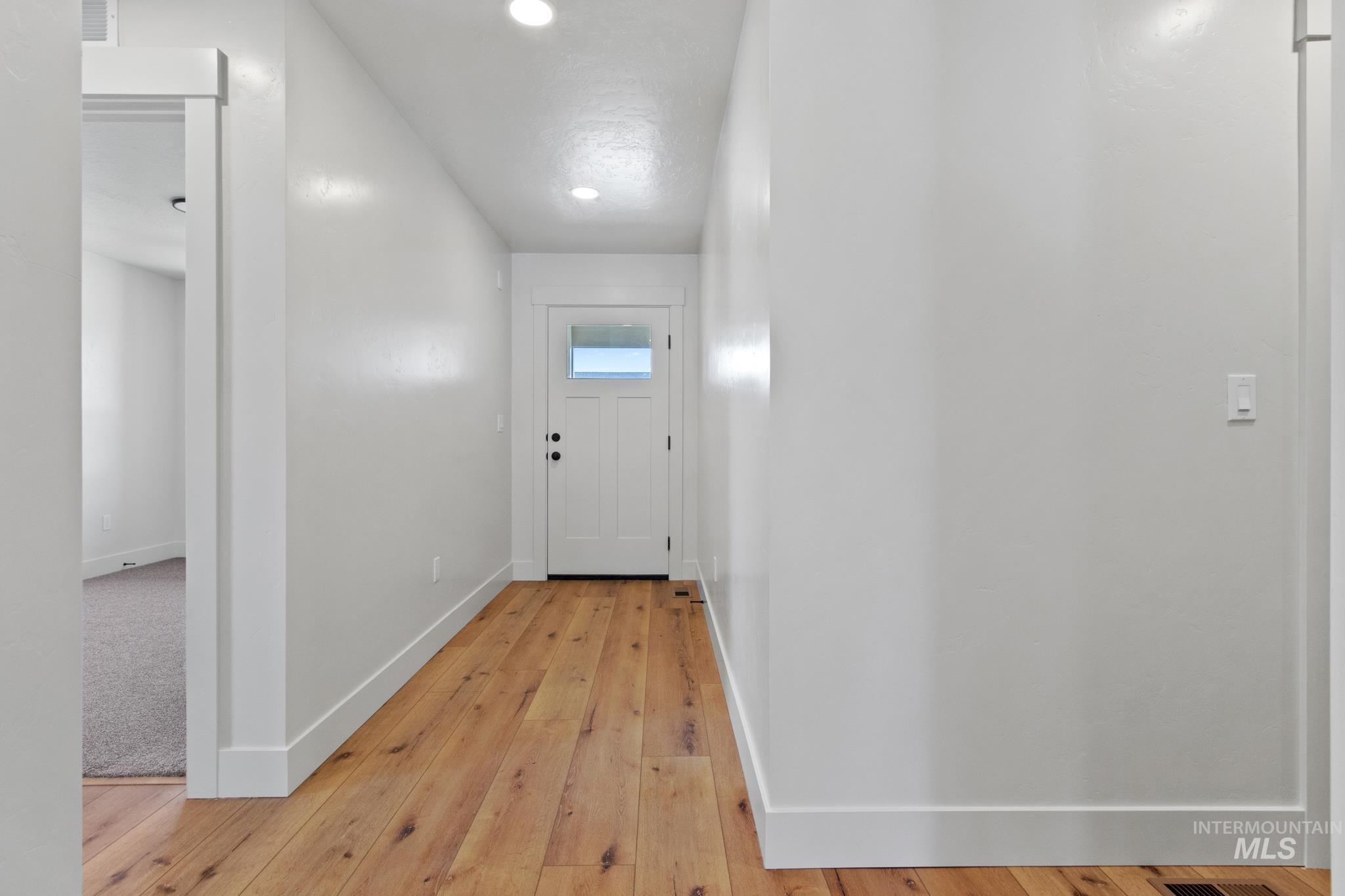 321 North 11th Street Parma, ID 83660 - Photo 3 of 36 Entryway featuring wood-finish flooring, recessed lighting, and a white paneled door with an upper window insert