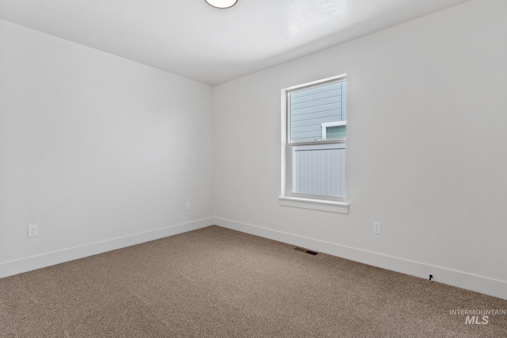 321 North 11th Street Parma, ID 83660 - Photo 8 of 36 Neutral-toned carpeting paired with white walls, baseboards, and window trim