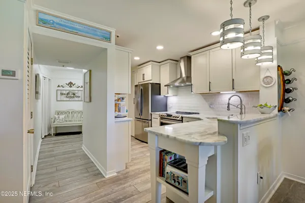 a kitchen with stainless steel appliances granite countertop a refrigerator and a stove