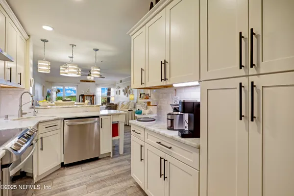 a view of a dining room with furniture a chandelier and wooden floor