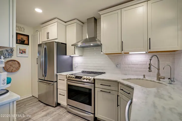 a kitchen with stainless steel appliances granite countertop a refrigerator sink and stove