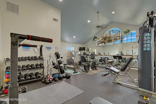 a view of a white house with a big yard and potted plants