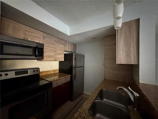 a kitchen with a refrigerator and a stove top oven
