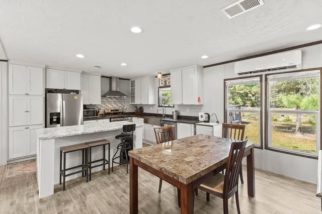 a kitchen with a table chairs refrigerator and cabinets