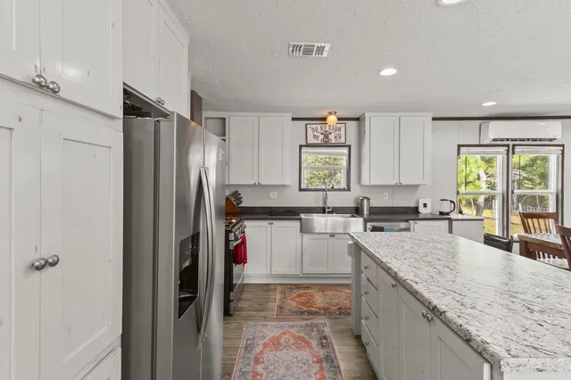 a kitchen with a refrigerator a sink and a large window