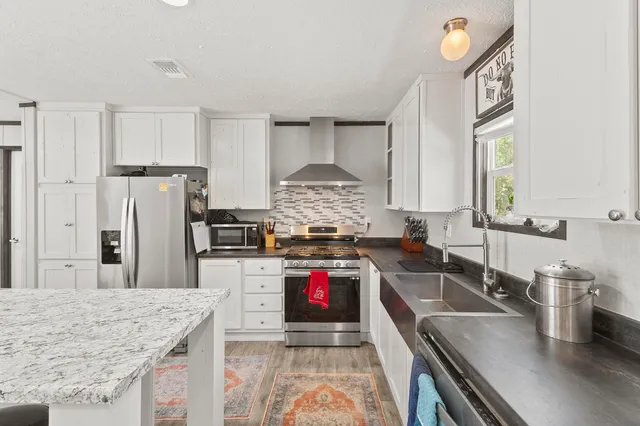 a kitchen with stainless steel appliances granite countertop a sink stove and refrigerator