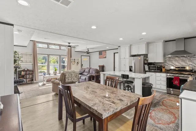 a kitchen with stainless steel appliances granite countertop a stove and a dining table
