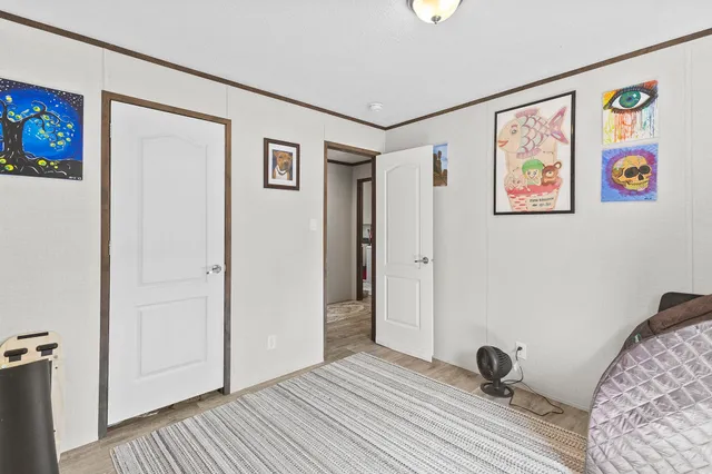 a view of a bedroom with wooden floor and hallway