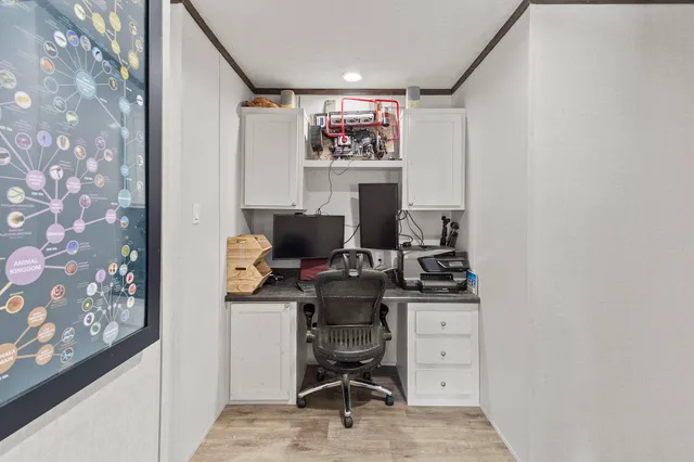 a view of a workspace with furniture and a window