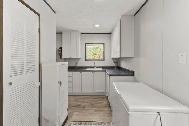 a kitchen with granite countertop white cabinets and white appliances