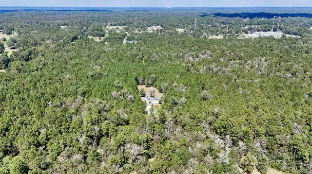 an aerial view of a houses with a yard and mountain view