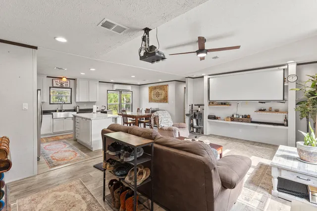 a living room with stainless steel appliances kitchen island granite countertop furniture and a view of kitchen