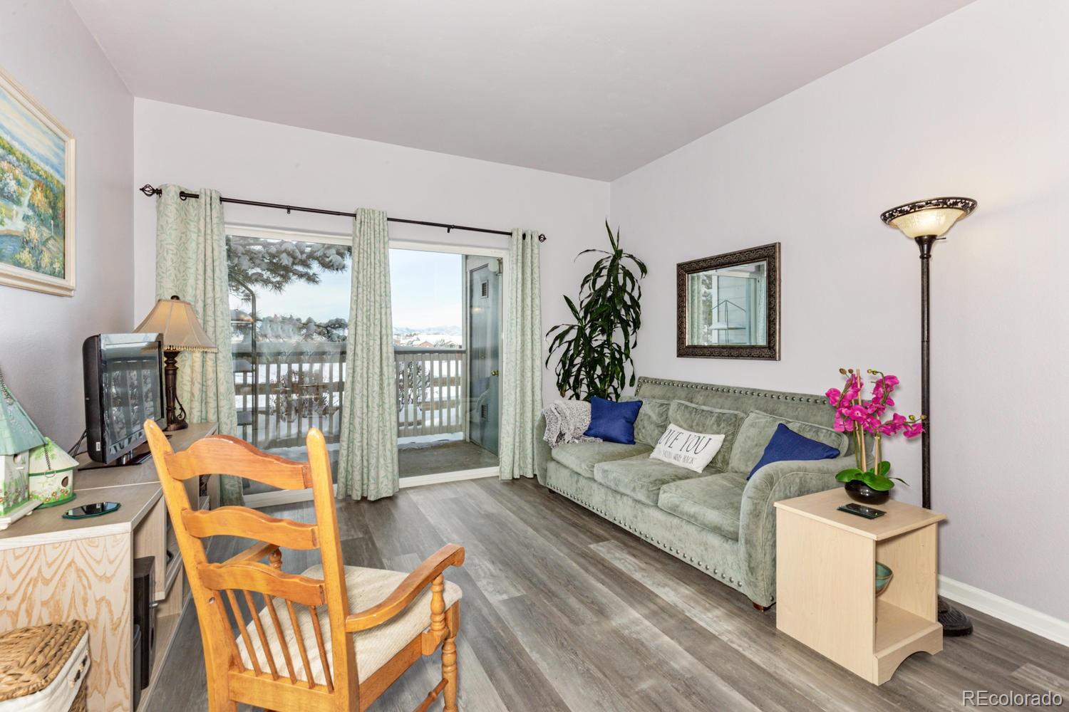 8425 Pebble Creek Way, Unit 104 Highlands Ranch, CO 80126 - Photo 1 of 16 a living room with furniture and a potted plant