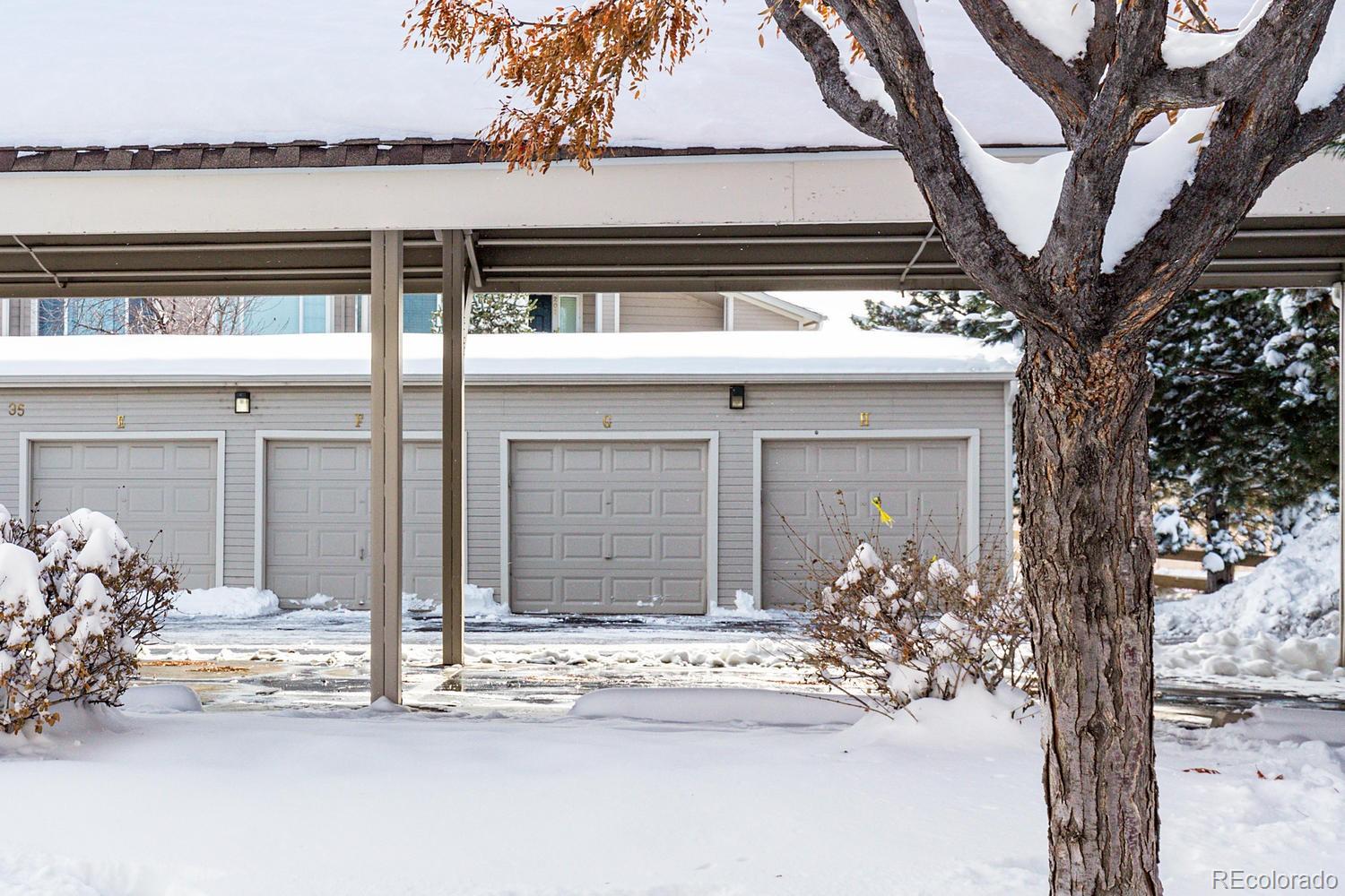 8425 Pebble Creek Way, Unit 104 Highlands Ranch, CO 80126 - Photo 14 of 16 a front view of a house with a yard and garage