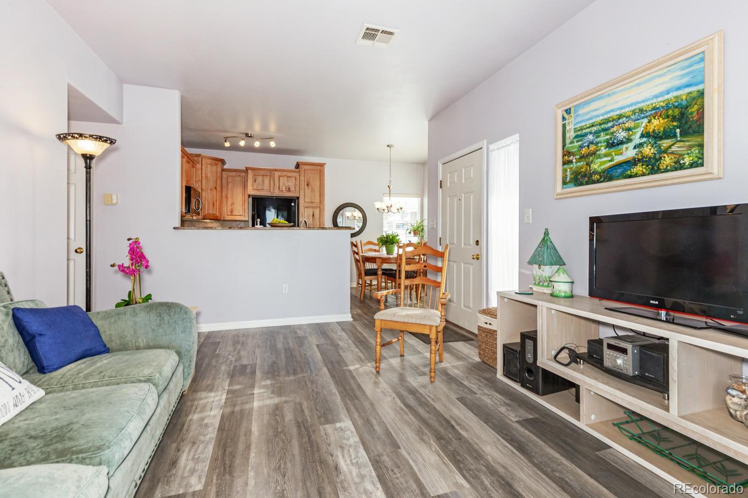 8425 Pebble Creek Way, Unit 104 Highlands Ranch, CO 80126 - Photo 3 of 16 a living room with furniture and a flat screen tv