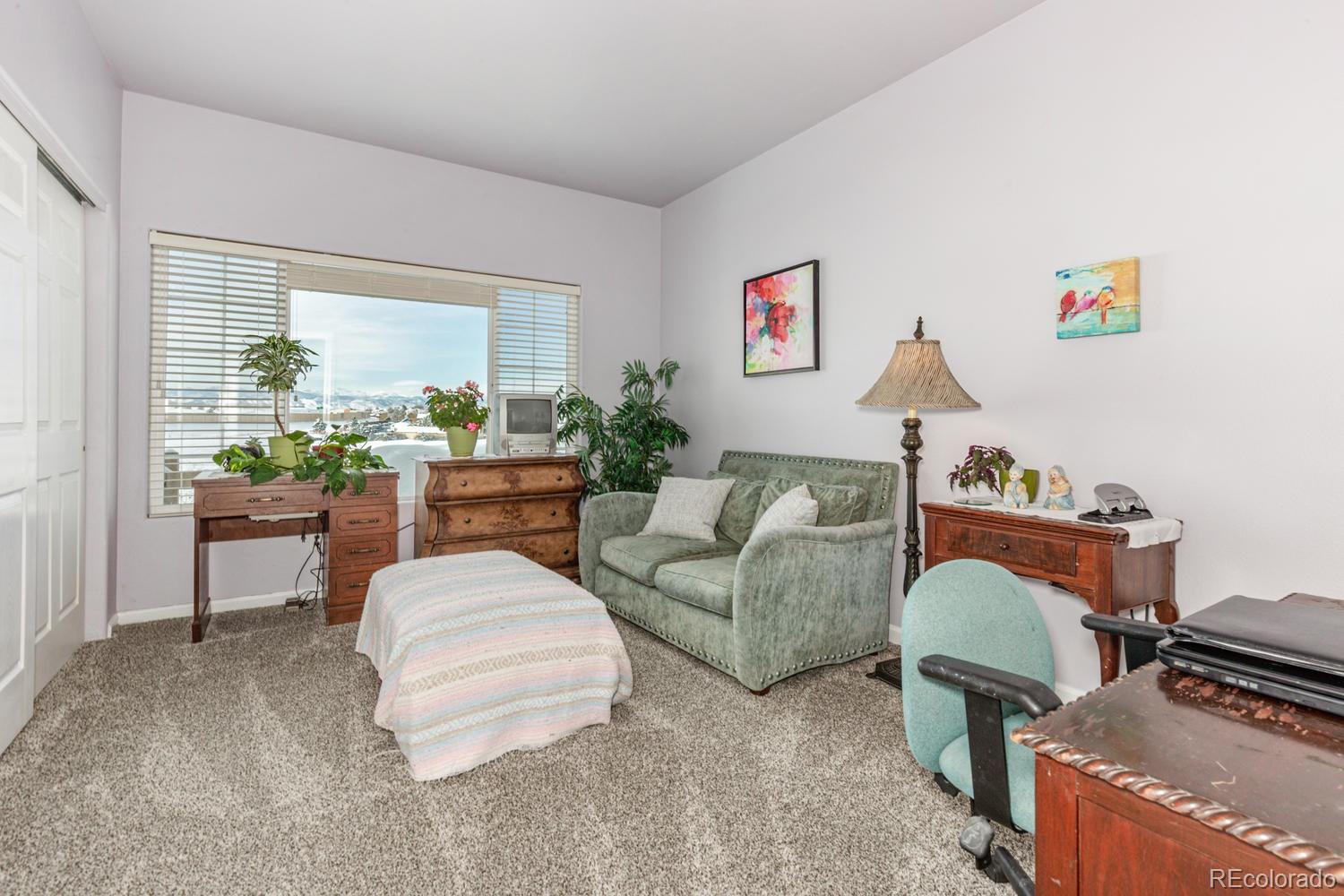 8425 Pebble Creek Way, Unit 104 Highlands Ranch, CO 80126 - Photo 7 of 16 a living room with furniture and a window