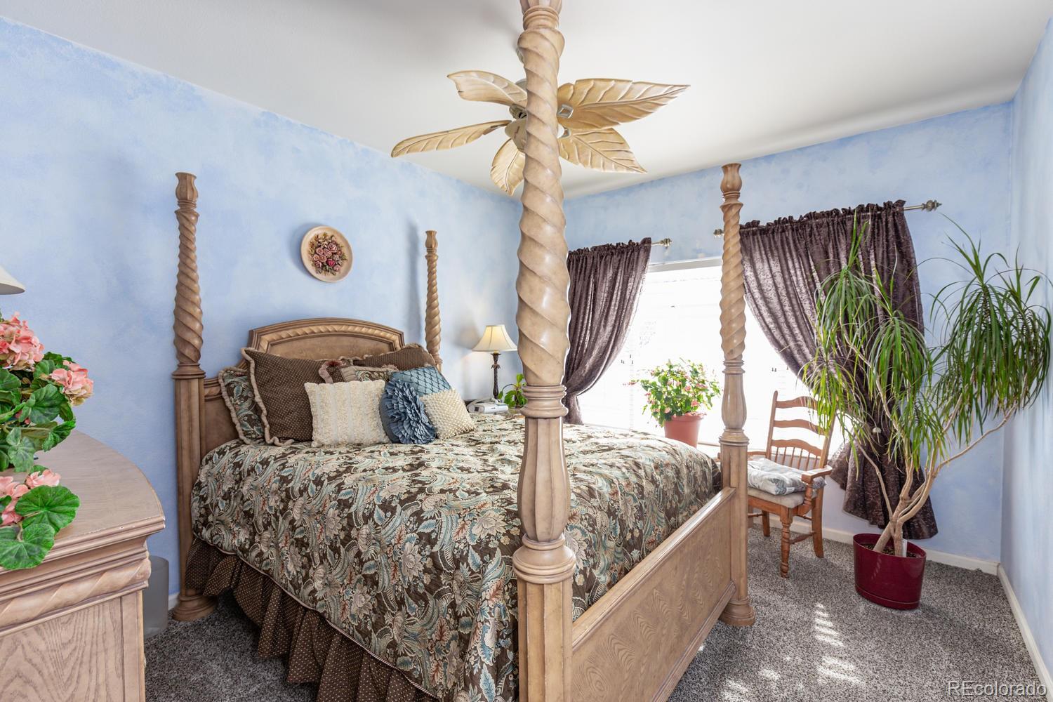 8425 Pebble Creek Way, Unit 104 Highlands Ranch, CO 80126 - Photo 10 of 16 a bed sitting in a bedroom next to a potted plant