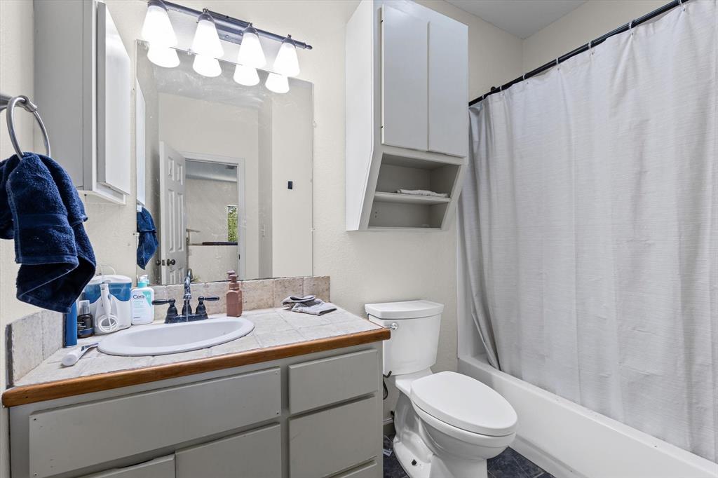 2007 South 7th Street Waco, TX 76706 - Photo 18 of 22 a bathroom with a sink a toilet a mirror and shower curtain