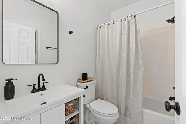 a bathroom with a sink a toilet and shower curtain