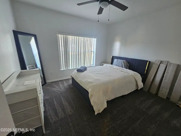 a bedroom with a bed and a flat tv screen on a dresser