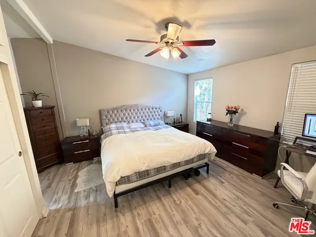 a bedroom with a bed and wooden floor