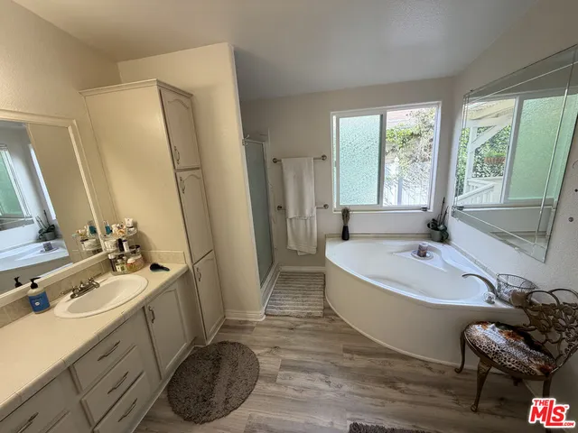 a bathroom with a tub sink and mirror
