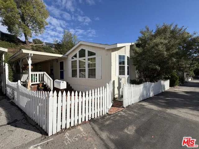 a view of a house with wooden fence