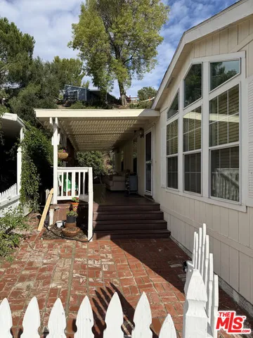 a view of a balcony with chairs and wooden fence