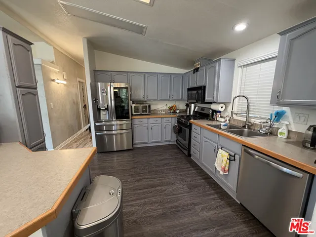 a large kitchen with granite countertop lots of counter top space and stainless steel appliances