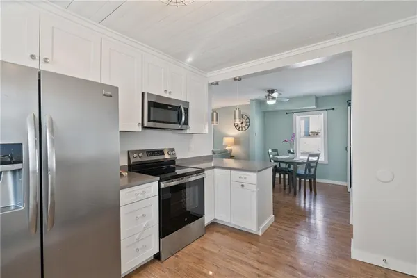 a kitchen with granite countertop a refrigerator stove and sink