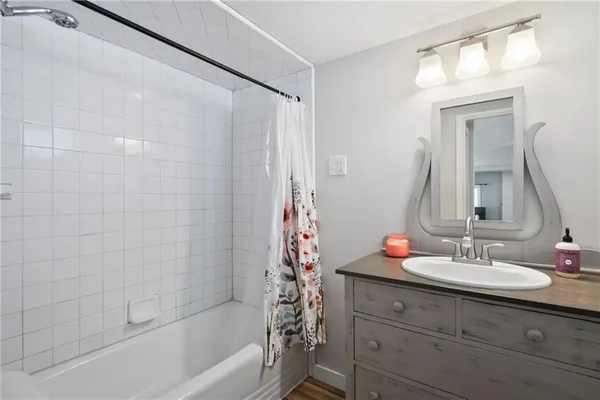 a bathroom with a granite countertop sink a mirror a vanity and a bathtub