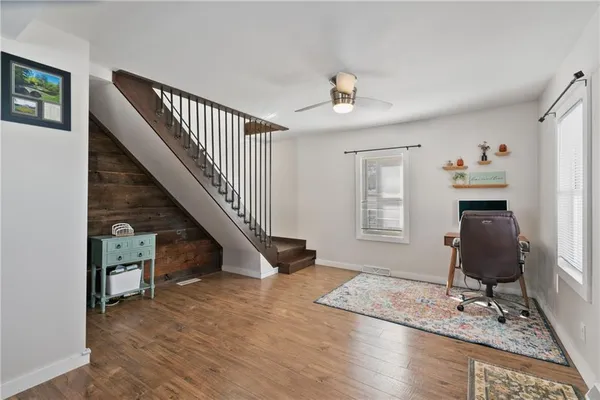 a living room with wooden floor and stairs