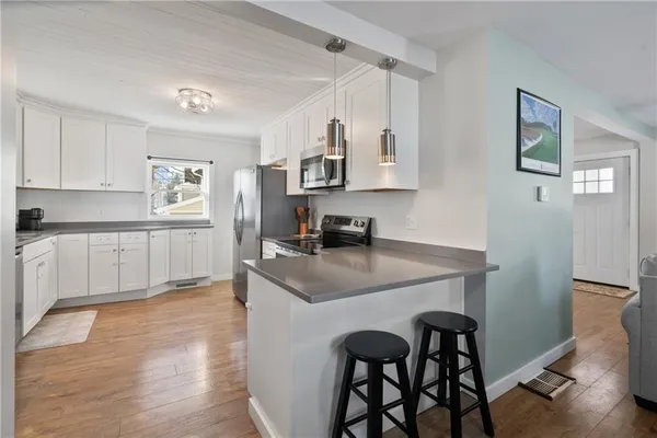 a kitchen with a table chairs refrigerator and cabinets