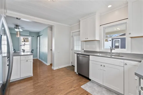 a kitchen with granite countertop a sink cabinets and stainless steel appliances