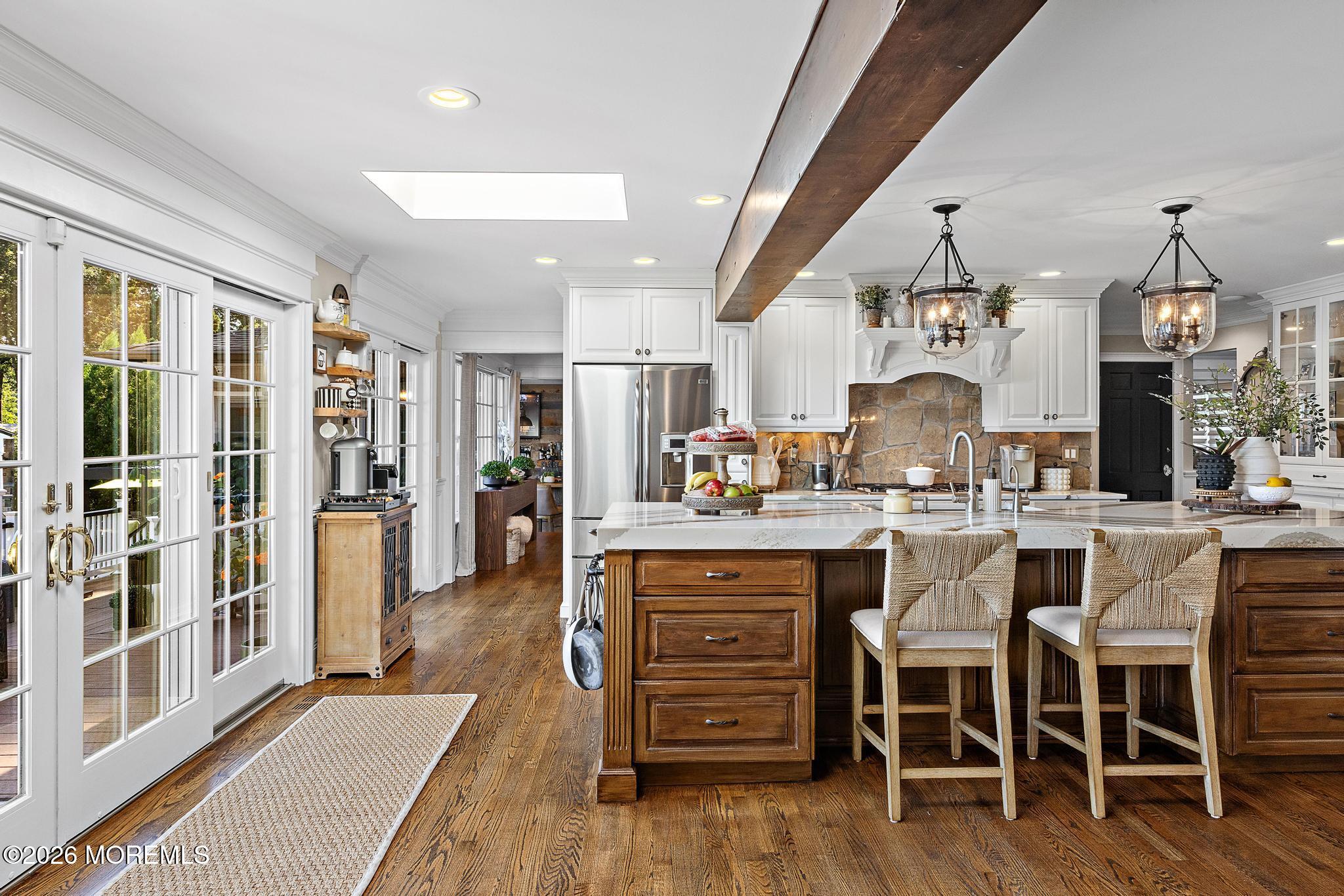 57 Beaver Dam Road Colts Neck, NJ 07722 - Photo 23 of 79 a kitchen with stainless steel appliances kitchen island granite countertop a table chairs sink and cabinets