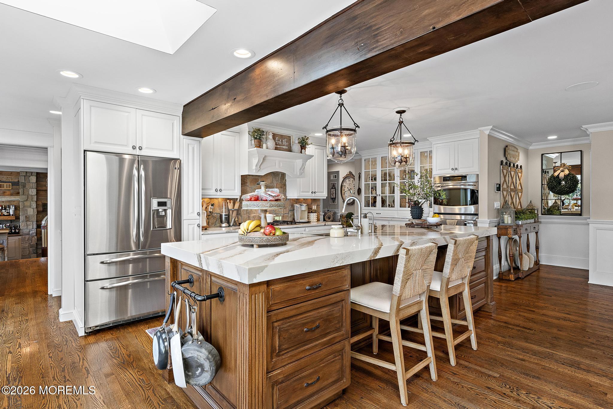57 Beaver Dam Road Colts Neck, NJ 07722 - Photo 24 of 79 a kitchen with stainless steel appliances kitchen island granite countertop a table chairs and a refrigerator