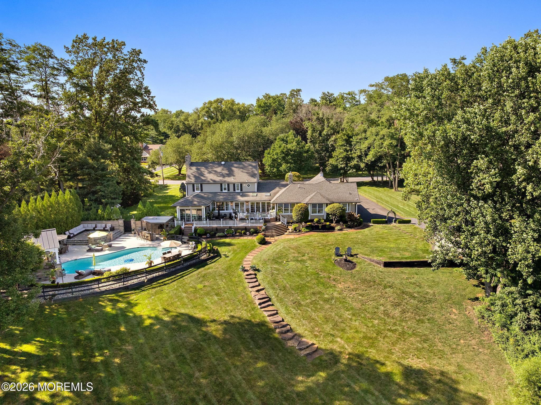 57 Beaver Dam Road Colts Neck, NJ 07722 - Photo 3 of 79 a view of a swimming pool with lawn chairs under an umbrella