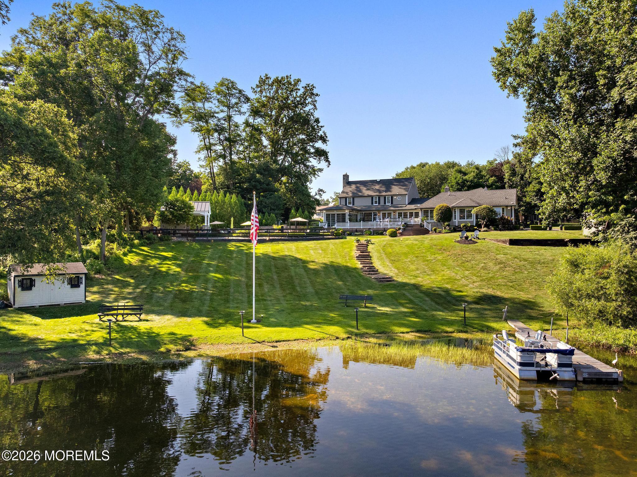 57 Beaver Dam Road Colts Neck, NJ 07722 - Photo 67 of 79 a view of a swimming pool with a lawn chairs under an umbrella