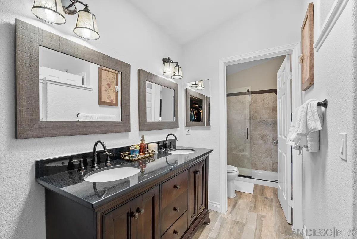 10109 Country Scenes Court Santee, CA 92071 - Photo 28 of 43 a bathroom with a granite countertop sink a mirror and shower