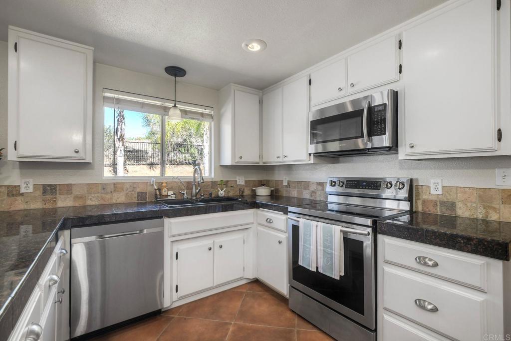 554 Taylor Street Vista, CA 92084 - Photo 20 of 51 a kitchen with cabinets appliances a sink and a window