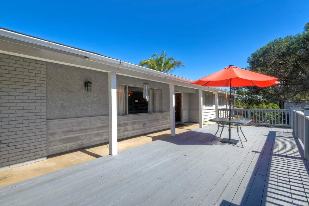 554 Taylor Street Vista, CA 92084 - Photo 49 of 51 a view of a patio with a table and chairs under an umbrella with wooden floor