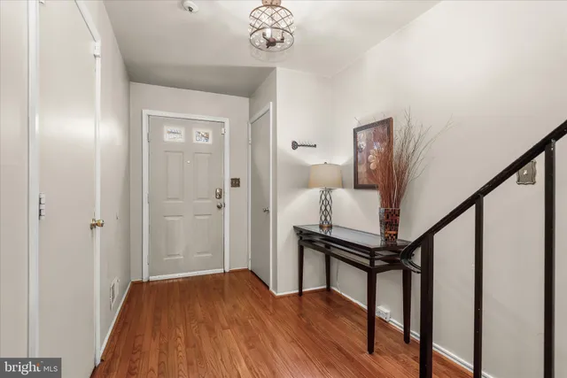 a view of a hallway with wooden floor and staircase