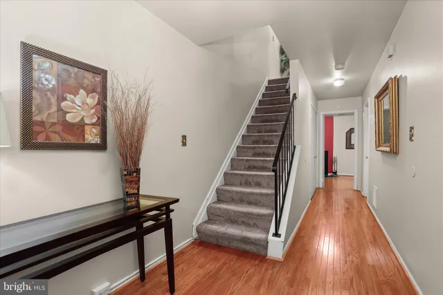 a view of a hallway with wooden floor and stairs
