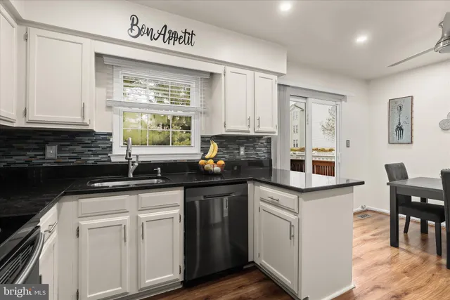 a kitchen with granite countertop white cabinets and white appliances