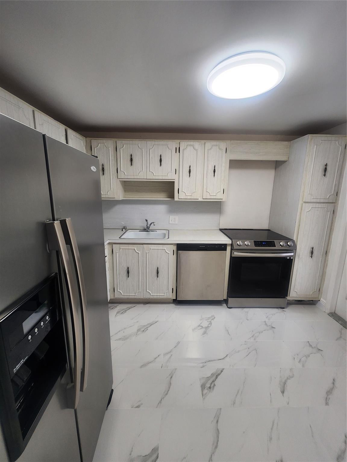 3051 North Course Drive Pompano Beach, FL 33069 - Photo 2 of 13 a kitchen with stainless steel appliances a refrigerator sink and cabinets