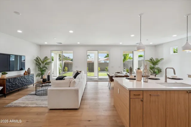 a large living room with stainless steel appliances granite countertop couches a flat screen tv