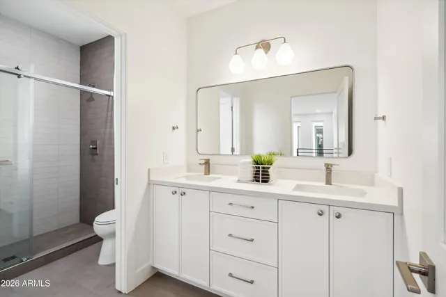 a bathroom with a double vanity sink toilet and shower