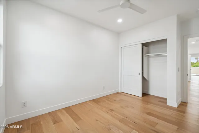 an empty room with wooden floor and closet